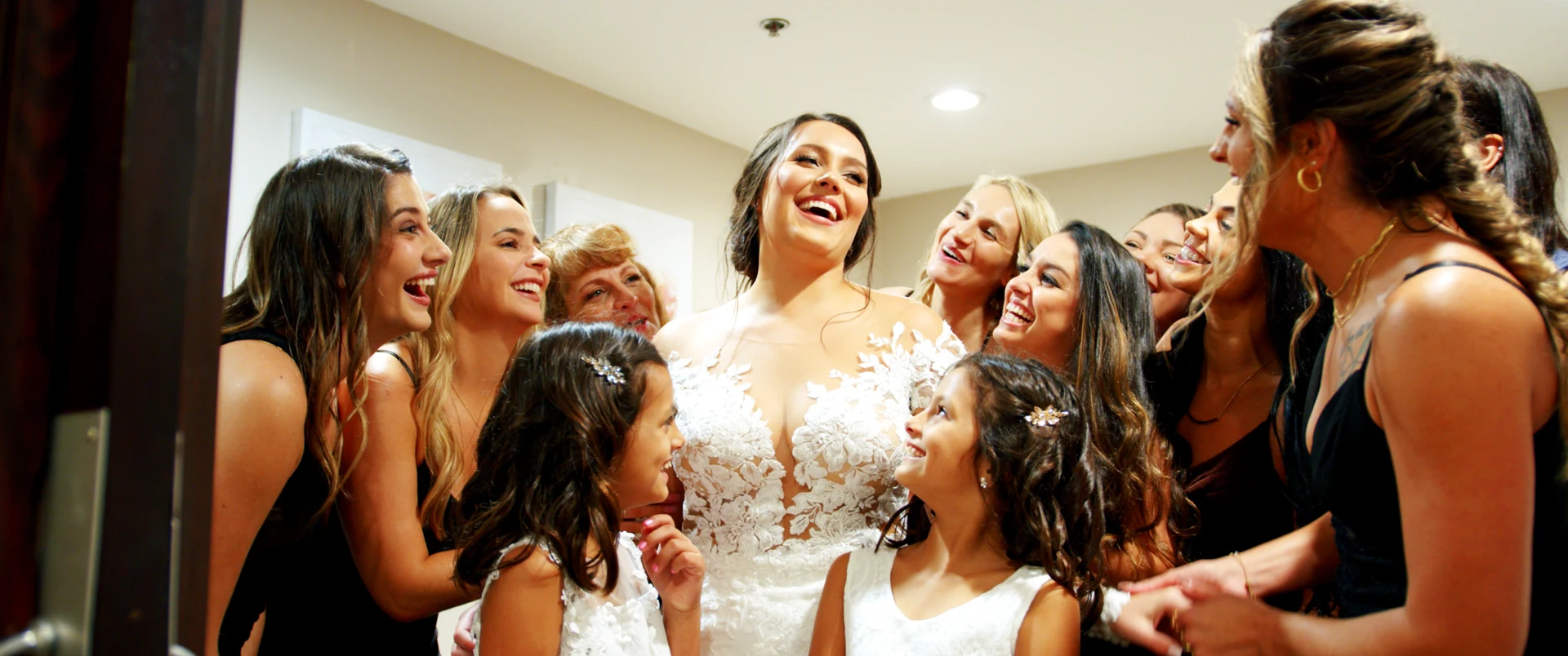 A bride laughing with her bridal party during preparations.