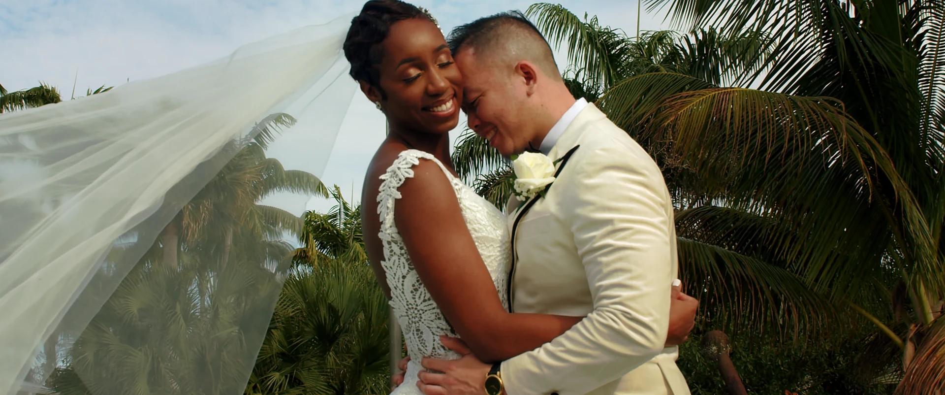 The Daos holding each other beneath the bride’s veil on their wedding day.
